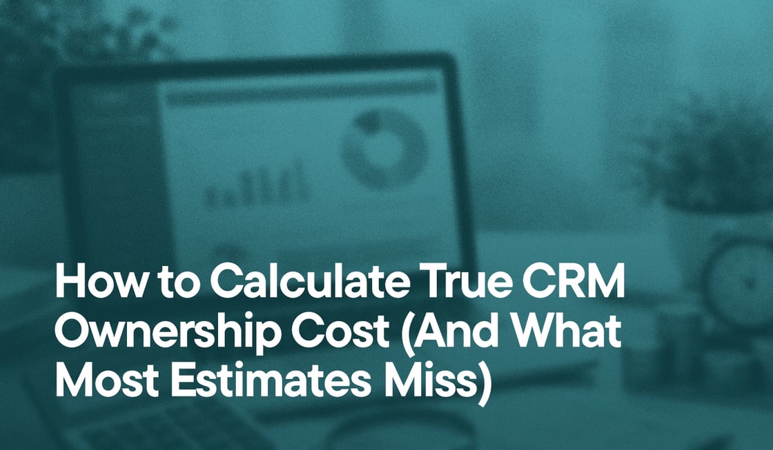 laptop with graphs and calculator with text - How to Calculate True CRM Ownership Cost (And What Most Estimates Miss)