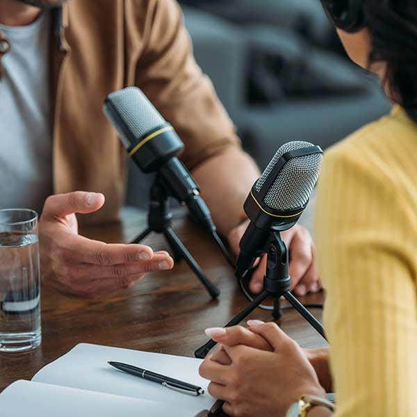 People talking into podcasting mics