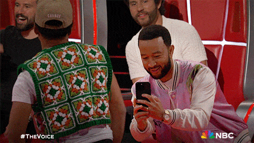 John Legend filming a vertical video on his iPhone