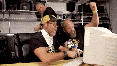 Men from the WWE banging on a computer trying to get it to work