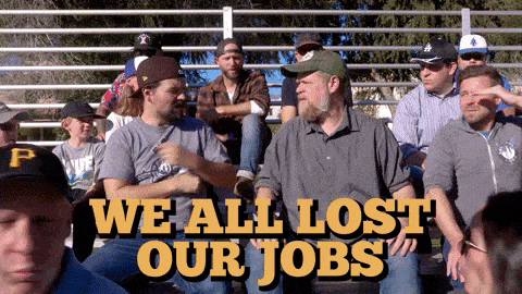 Men sitting on bleachers, one says to the group 'We all lost our jobs'