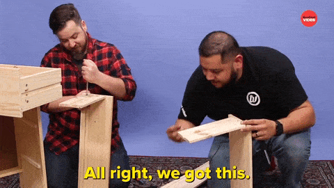 Two men building furniture. One says, 'All right, we got this.' The other says, 'We got it.'