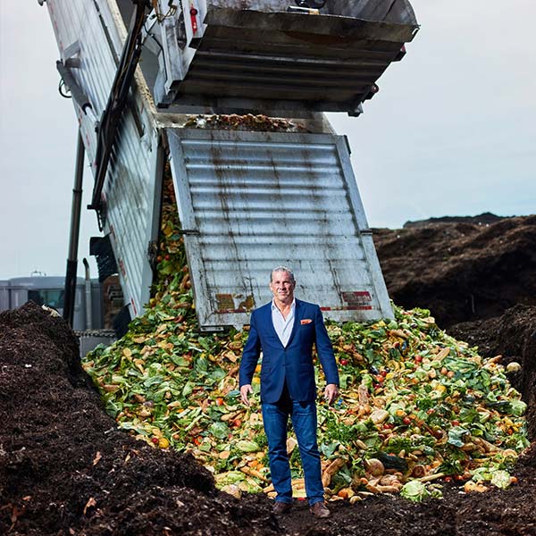 Mr. Vigliotti stands in front of a mountain of organic waste material