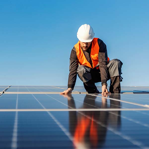 Technician installing solar panels on a roof