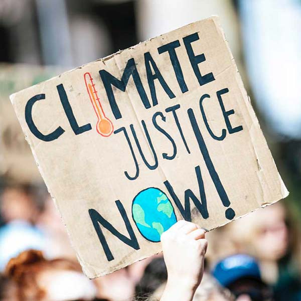 A sign from a climate justice rally that reads "Climate Justice Now!"