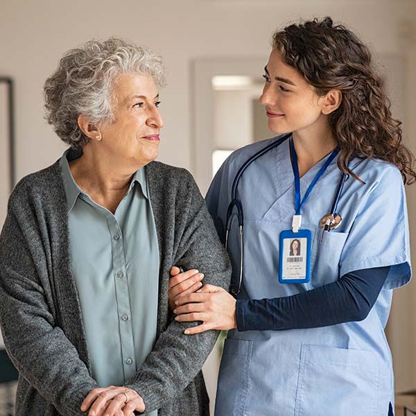 Nurse walks alongside smiling elderly patient